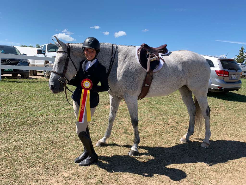 Chloe at a competition with her grey horse